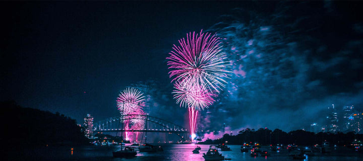 fireworks going off over water during new years eve